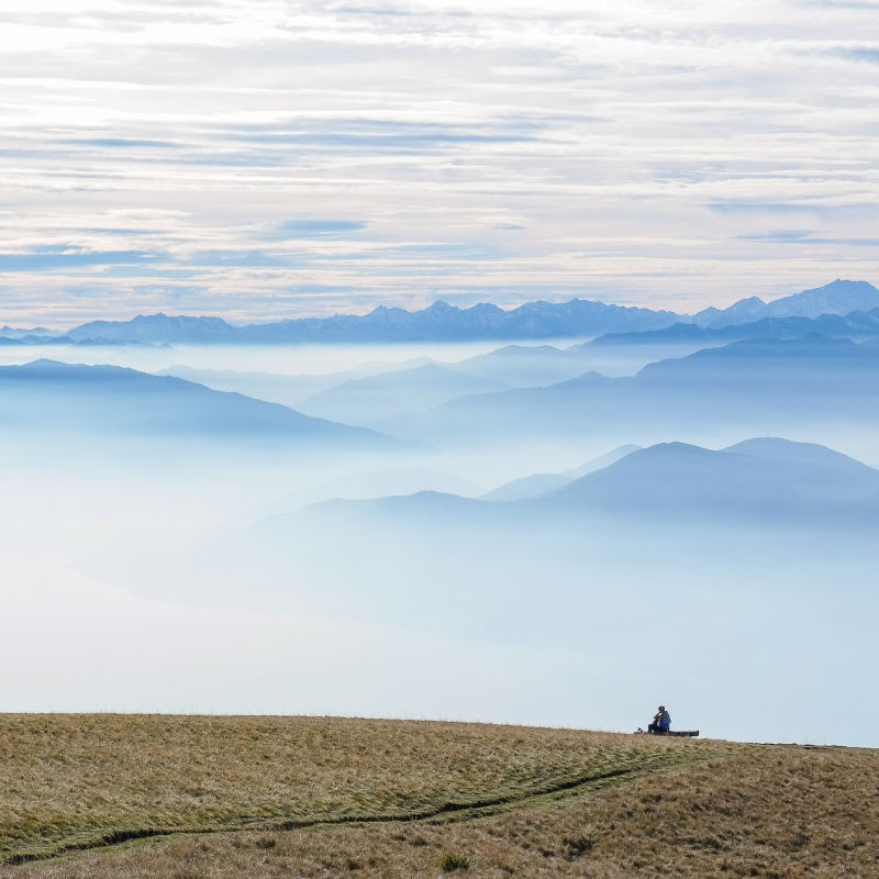 man sitting alone on mountain